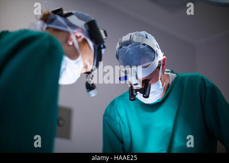 I chirurghi indossando loupes chirurgica durante l'esecuzione dell'operazione Foto Stock