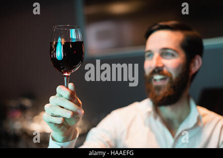 Barista guardando il bicchiere di vino rosso Foto Stock