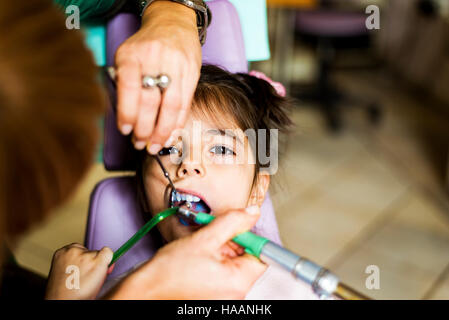 Little Girl getting trattamento dentale in studio dentistico Foto Stock