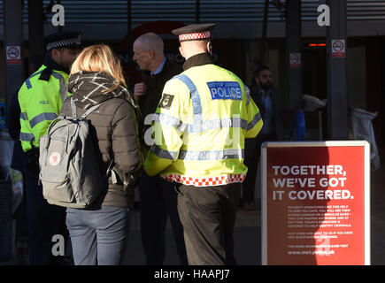 Un funzionario di polizia parla di un " commuter " alla Vauxhall stazione autobus di Londra Sud, per evidenziare la introduzione di anti-terrorismo pattuglia di polizia di unità di tutta la capitale. Foto Stock