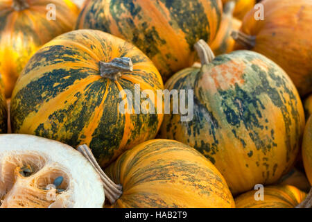 Alcune zucche sul mercato degli agricoltori, una zucca tagliata a metà Foto Stock