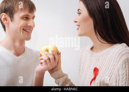 Felice felice giovane azienda un Apple Foto Stock