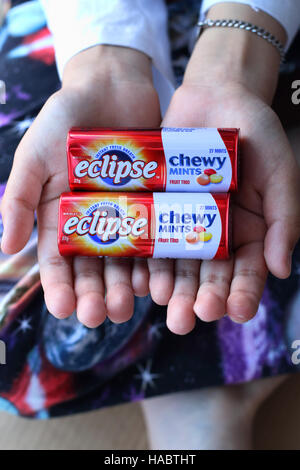 Un bambino mano azienda Australian Eclipse zecche fragrante Foto Stock