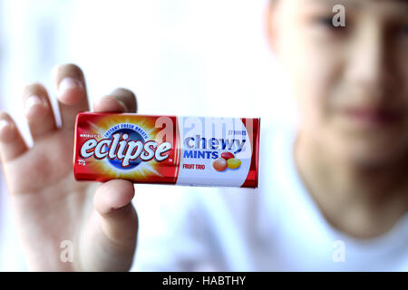 Un bambino mano azienda Australian Eclipse zecche fragrante Foto Stock