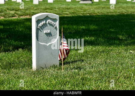 Primo piano di una lastra tombale con una bandiera americana presso il Cimitero Nazionale di Arlington, Arlington, Virginia, Stati Uniti d'America, del Memorial Day weekend. Foto Stock