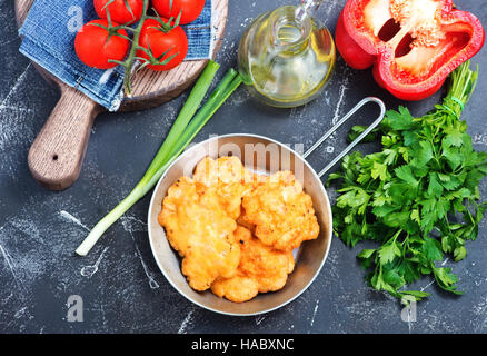 Cotolette di pollo nella padella e su un tavolo Foto Stock