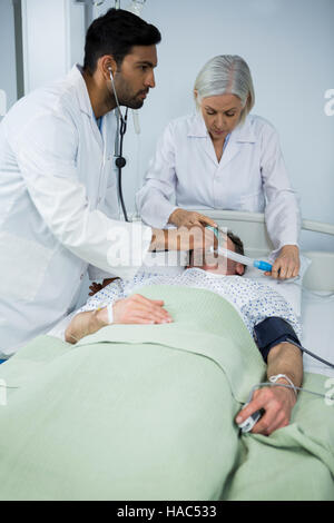 Medico posizionando una maschera ad ossigeno sulla faccia di un paziente Foto Stock