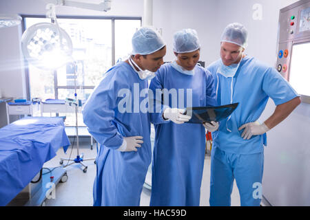 I chirurghi esaminando x-ray nella camera operativa Foto Stock