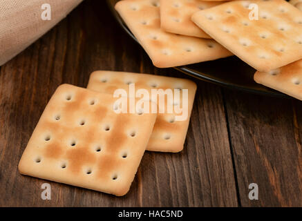 Saltine cracker on dark tavolo in legno Foto Stock