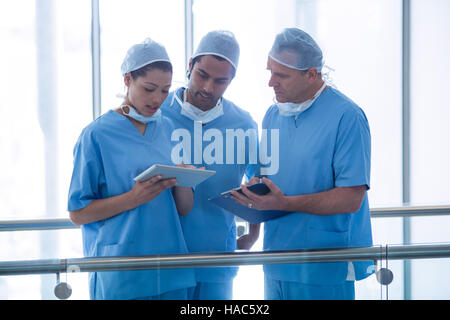 Il team di chirurghi a discutere su tavoletta digitale Foto Stock
