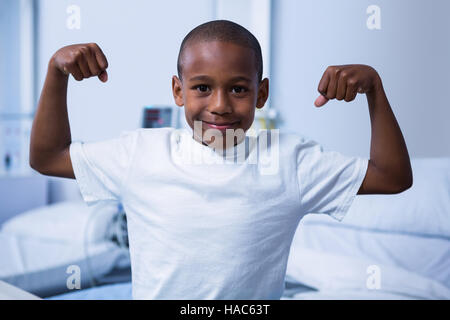 Ritratto di ragazzo flettendo i suoi muscoli in reparto Foto Stock