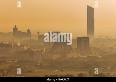 Il fumoso skyline di Dubai su Wafi piramidi poco dopo l'alba a Dubai, Emirati arabi uniti Foto Stock