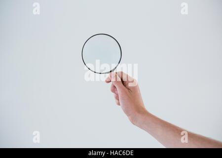 Mano che tiene la lente di ingrandimento Foto Stock