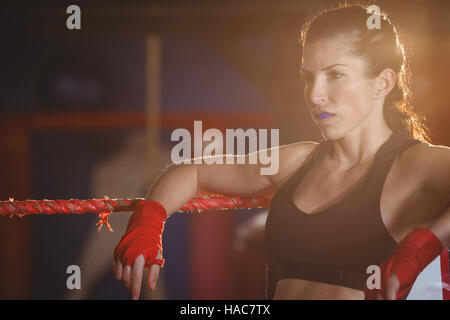 Riflessivo boxer femmina in seduta l'anello Foto Stock