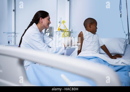 Medico donna dando una iniezione al paziente in reparto Foto Stock