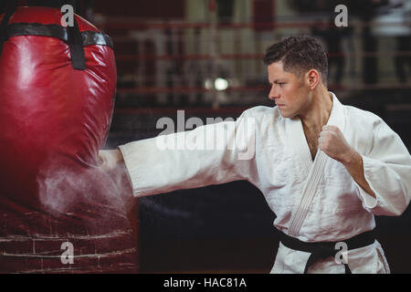 Lettore di Karate a praticare il karate con sacco da boxe Foto Stock