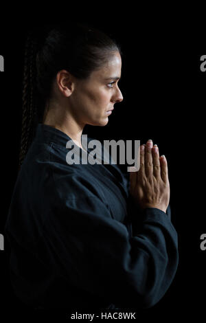 Karate femmina player nella preghiera pongono Foto Stock