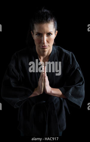 Karate femmina player nella preghiera pongono Foto Stock