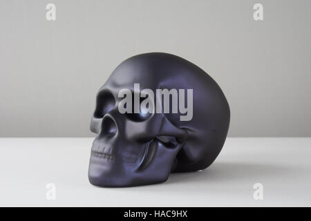 In plastica nera teschio umano su sfondo bianco Foto Stock