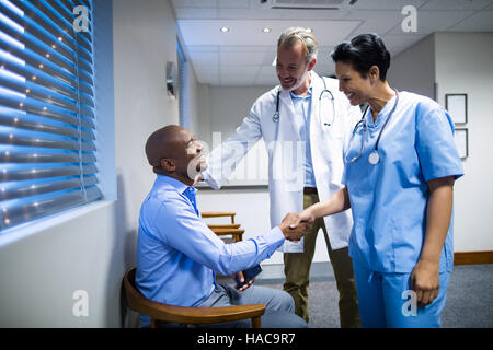 I medici si stringono la mano con il paziente Foto Stock