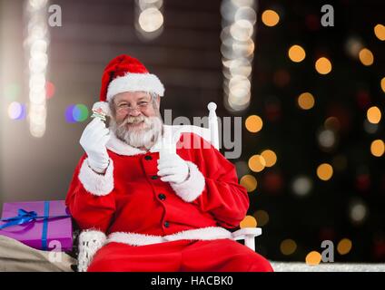 Santa Claus tenendo un bicchiere di latte e biscotti Foto Stock