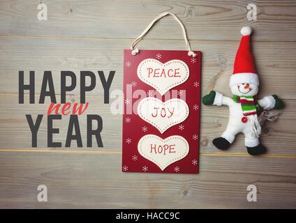 Felice Natale messaggio sullo sfondo di legno con shopping bag e pupazzo di neve Foto Stock