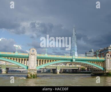 I telai di Shard lo sfondo dietro Southwark Bridge sulla riva sud del Tamigi, Londra, Regno Unito. Foto Stock