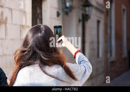 Femmina di scattare le foto sul suo cellulare, Venezia, Italia. Foto Stock