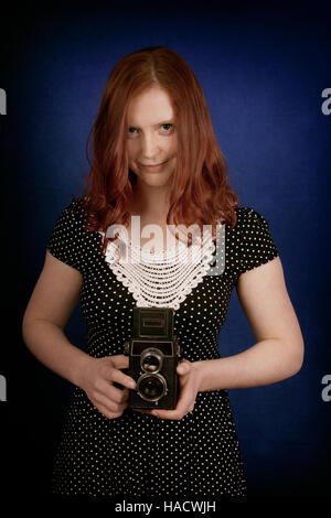 Giovane donna con la vecchia macchina fotografica Foto Stock