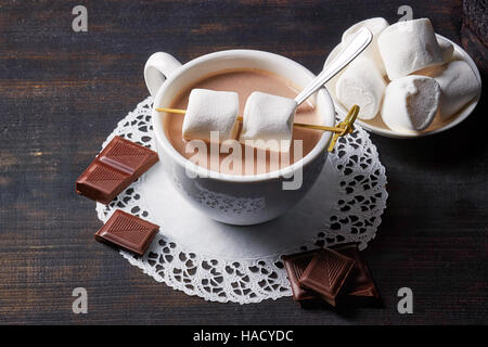 Tazza di cioccolata calda a bere con dolci on dark tavolo in legno Foto Stock