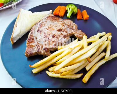 Braciole di maiale alla griglia (collo tagliato) con pane e patatine fritte Foto Stock