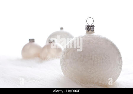 Disposizione di White Christmas baubles sulla pelliccia bianca Foto Stock