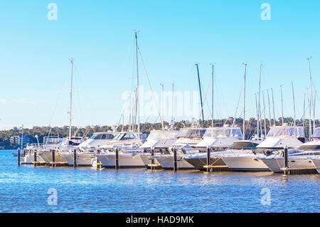 Barche schierati al loro posti barca del fiume Swan a Perth, Western Australia. Foto Stock