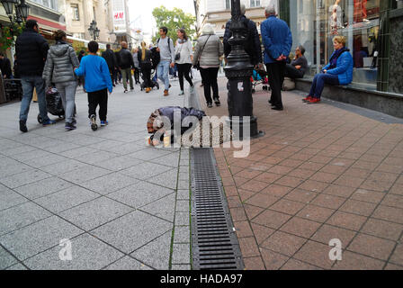 Budapest, Ungheria. Un senzatetto chiede la carità in una strada del centro storico. Foto Stock