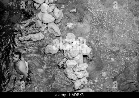 Giovane uomo godendo di un bagno rilassante nella hot springs Foto Stock