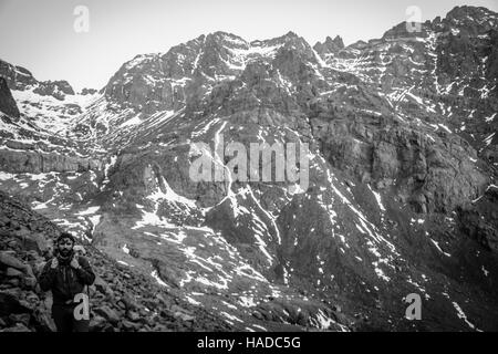 Ritratto ambientale di un alpinista sulla salita di picco Jbel Toubkal in Marocco Foto Stock