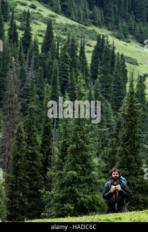 Ritratto ambientale di un alpinista su una pausa durante il treeking. Foto Stock