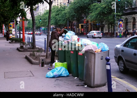 Budapest, Ungheria. Una ragazza povera rovistare nei bidoni in Ulloi utca (Inglese : Ulloi street). Foto Stock