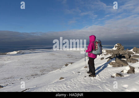 Walker godendo la vista ovest sopra la valle dell'Eden dall'altopiano di cima della Croce cadde in inverno, Pennines del nord, Cumbria Regno Unito Foto Stock