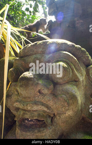 Le scimmie avendo divertimento sulle statue in pietra di sante indù Monkey Forest. Ubud. Bali. L'Ubud Monkey Forest è una riserva naturale e complesso tempio in Ubud, Ba Foto Stock