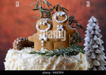 Festa di Natale vacanze impediva di procedere centrotavola bianco torta al cioccolato con pan di zenzero uomini cooklies e il rosmarino e decorazioni di alberi in un moderno rusti Foto Stock