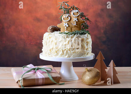 Festa di Natale vacanze impediva di procedere centrotavola bianco torta al cioccolato con pan di zenzero uomini cooklies e il rosmarino e decorazioni di alberi in un moderno rusti Foto Stock