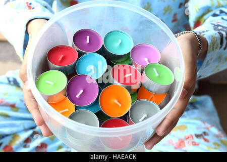 Bambino azienda colorato candele profumate in contenitore trasparente in plastica Foto Stock