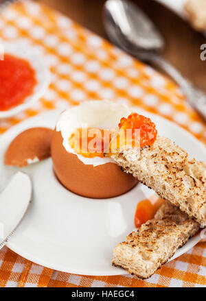 Uova sode con caviale rosso, pane tostato e caffè per colazione Foto Stock