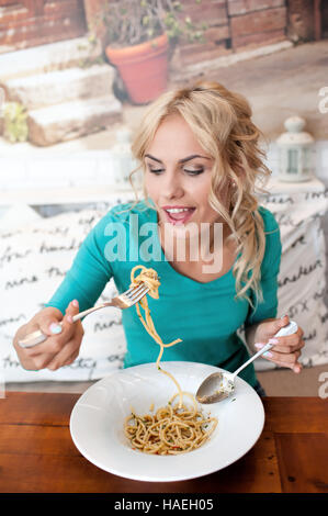 La giovane donna mangia da sola nel ristorante Foto Stock