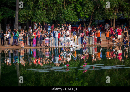 Gruppi di turisti si riuniscono ogni mattina per guardare il sole sorgere oltre Angkor Wat tempio complesso a Siem Reap, Cambogia. Foto Stock