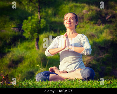 Giovane sportivo da donna adatta a praticare lo yoga Lotus pongono oudoors Foto Stock