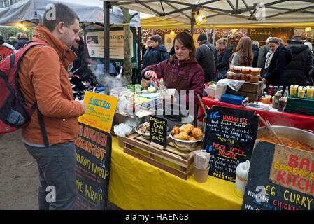 Un cliente di essere servito a una pressione di stallo streetfood a Stockbridge mercato di domenica a Edimburgo, Scozia. Foto Stock