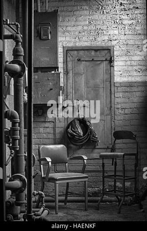 Nascosto break room - hideaway spot per la conversazione o la pausa caffè in un vecchio edificio con due vuoti sedie vintage - B&W Foto Stock