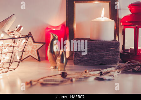 Rustico in legno decorazione di Natale in calde e luminose in scena con candele accese e luci Foto Stock